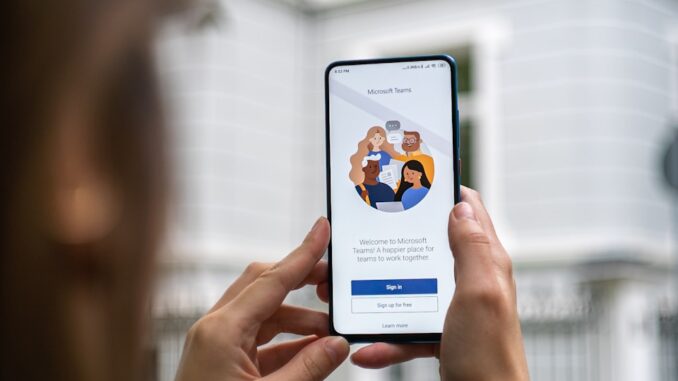 Teams va remplacer definitivement Skype personne tenant un smartphone Android blanc pour se connecter à Teams