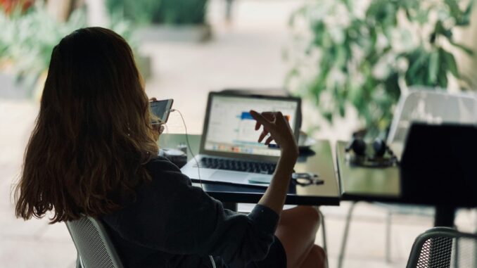 Magazine de la stratégie digitale : Un outil incontournable pour les entreprises modernes femme assise sur une chaise devant une table avec un ordinateur portable pour mettre en place une stratégie digitale pour son commerce