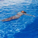 Femme dans une piscine savoure un moment de détente.