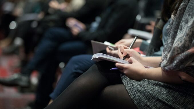 Confédération et Journalisme : Vers une Union pour une Information Libre et Fiable photographie sélective de journaliste assis sur des chaises tout en écrivant sur des cahiers