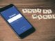 iPhone 6 gris sidéral avec écran de connexion Facebook à proximité des tuiles de Scrabble des réseaux sociaux