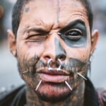 homme avec un piercing au nez argenté et d'autres sur son visage